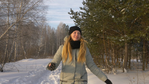 身穿夹克在冬季森林中散步的女孩29秒视频