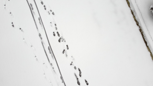 空中无人驾驶飞机在清雪上看到脚印和滑雪足迹视频