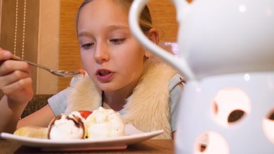 在餐厅餐桌上吃冰淇淋甜点的十几岁的女孩视频