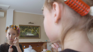 穿着卷卷发头发的少女女孩在卧室前镜中涂色乳霜10秒视频