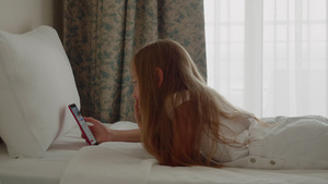 躺在床上并使用智能手机的可爱少女21秒视频