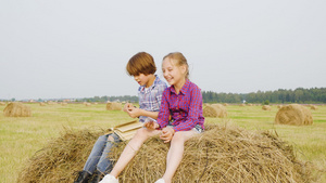 十几岁的男孩和女孩坐在农村田野的干草堆上无忧无虑的18秒视频