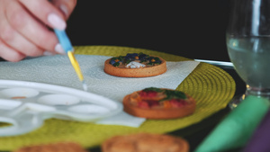 艺术装饰女性在调色盘上涂涂有刷子和食品25秒视频