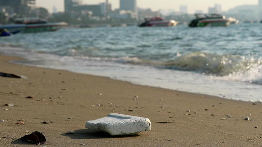 海滩上的泡沫塑料橡胶和废物留在海滩上海浪将它们吹入海视频