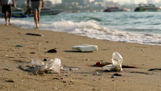 人们用塑料橡胶在海滩上行走废物留在海滩上海浪将它们视频