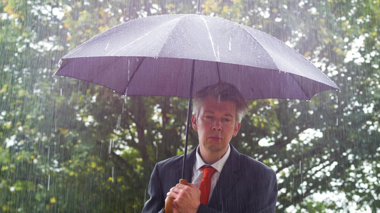 商人躲在雨伞下躲避雨雨下的雨伞下视频