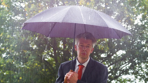 商人躲在雨伞下躲避雨雨下的雨伞下22秒视频