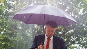 商人躲在雨伞下躲避雨雨下的雨伞下21秒视频