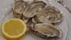 柠檬特写冰上的牡蛎餐厅大盘子上半壳上的新鲜牡蛎健康34秒视频