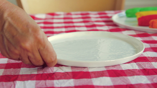 女人把白色的空盘子放在桌子上视频