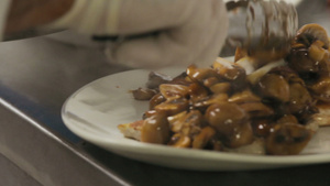 厨师准备一盘配蘑菇的菜酱里有蘑菇被烤鱼烧成白色盘子6秒视频