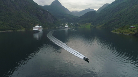 夏日盖朗厄尔峡湾的小型机动快艇和大型游轮挪威鸟瞰图视频