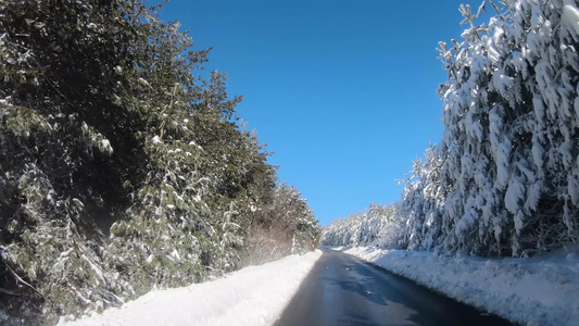 冬季沿森林道路行驶的汽车在雪地乡村道路上驾驶第一视角视频