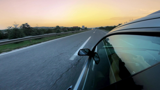 日出时在高速公路上驾驶的一辆汽车后反射镜视频