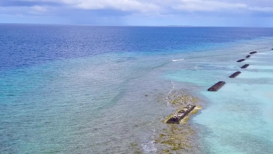 以蓝水和清洁沙土背景为特色海湾海滩假日的空中无人驾驶视频
