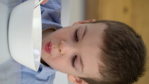 每天早上吃甜玉米片和牛奶的小饥饿男孩独自坐在厨房桌旁14秒视频