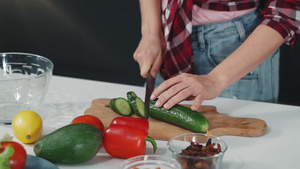 在餐桌上切新鲜黄瓜片用温柔的手站在厨房里做午餐或晚餐22秒视频