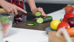 低角度在餐桌上切黄瓜用温柔的手站在厨房里做午餐或晚餐31秒视频
