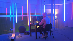 黑客在一个有彩色荧光灯的房间工作9秒视频
