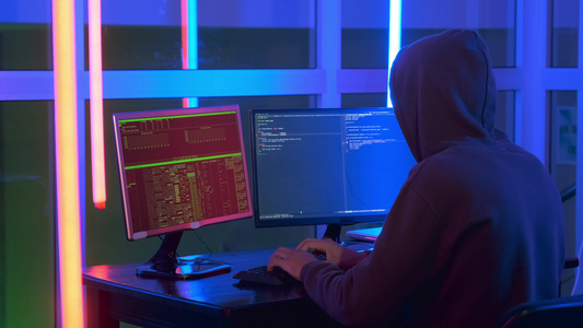 黑客身穿深黑的中镜头在计算机上工作视频