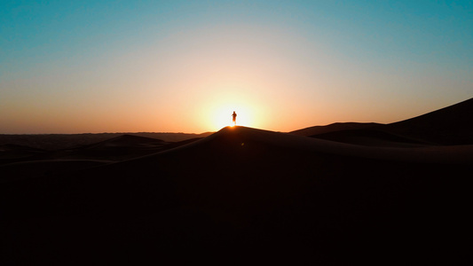 航拍沙漠夕阳下的人物剪影[正面人物]视频
