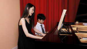 音乐教师教儿童弹奏钢琴16秒视频