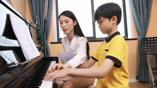音乐家教指导男孩弹奏钢琴视频