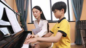 音乐家教指导男孩弹奏钢琴25秒视频