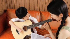 音乐家教指导男孩弹吉他17秒视频