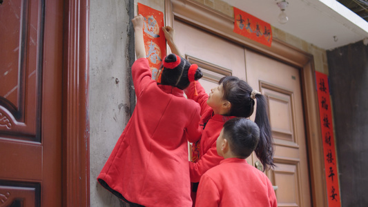 4K实拍新年春节小朋友一起门上贴对联视频