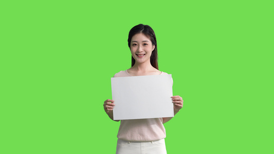4k穿休闲装的女生手拿白板展示动作绿幕抠像视频视频