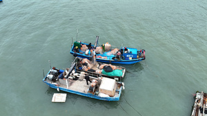航拍福建旅游东山岛渔村渔船上出海前检查渔网劳动的渔民4k素材47秒视频
