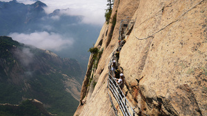 陕西旅游西岳华山最险段长空栈道悬崖旁的游客与云海4k素材55秒视频