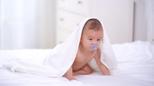 4k披着毛毯的婴儿在床上爬行视频