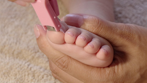 4K母婴呵护妈妈给宝宝剪脚趾甲实拍35秒视频