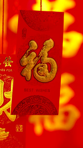 红色喜庆背景前悬挂红包福字礼盒实拍静物视频传统文化视频
