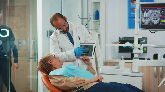 与高级病人一起检查牙齿X光的口腔学家视频