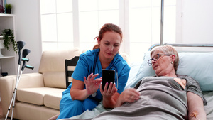 帮助年长妇女使用智能电话的女护士19秒视频