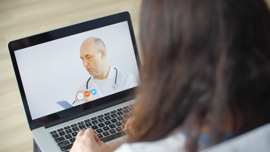 医生通过笔记本电脑屏幕上的视频通话为患者提供建议生病视频