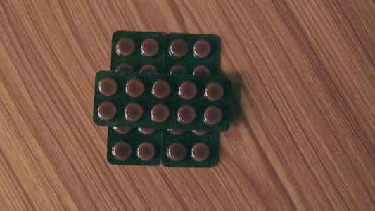 装在泡水器圆形药片或木桌底的抗生素药丸中的胶囊堆积视频
