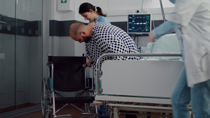 医疗队帮助有腿骨折的病人坐轮椅19秒视频
