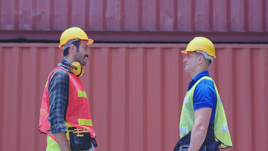 两名工人技术员或工程师在货运集装箱工作场所共同讨论视频