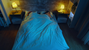年轻夫妇睡在一个房间的顶层景象蓝色月光从窗户穿进来12秒视频