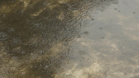 季风雨落在地上轻大雨滴落在混凝土屋顶表面录像雨落音效视频