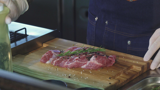 一名专业厨师加橄榄油制作猪肉的橄榄油视频