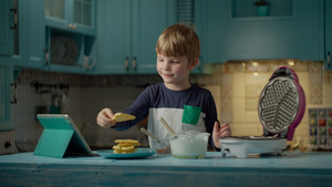 学龄前男孩看平板电脑用奶油和巧克力吃自制华夫饼50秒视频