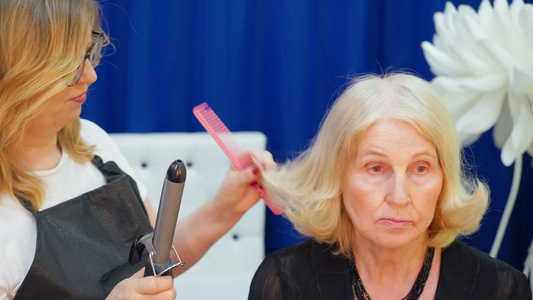沙龙发型师替年长女性打理头发视频
