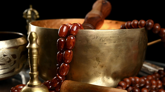 藏族歌唱铜碗棕色木桌上有木梆子冥想物和替代药物特写视频