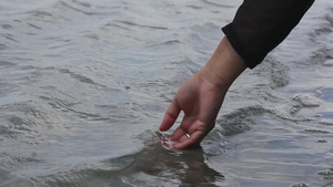 一名旅游妇女手触摸海水18秒视频