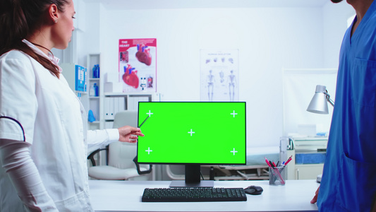 医生用绿色屏幕在计算机上解释视频